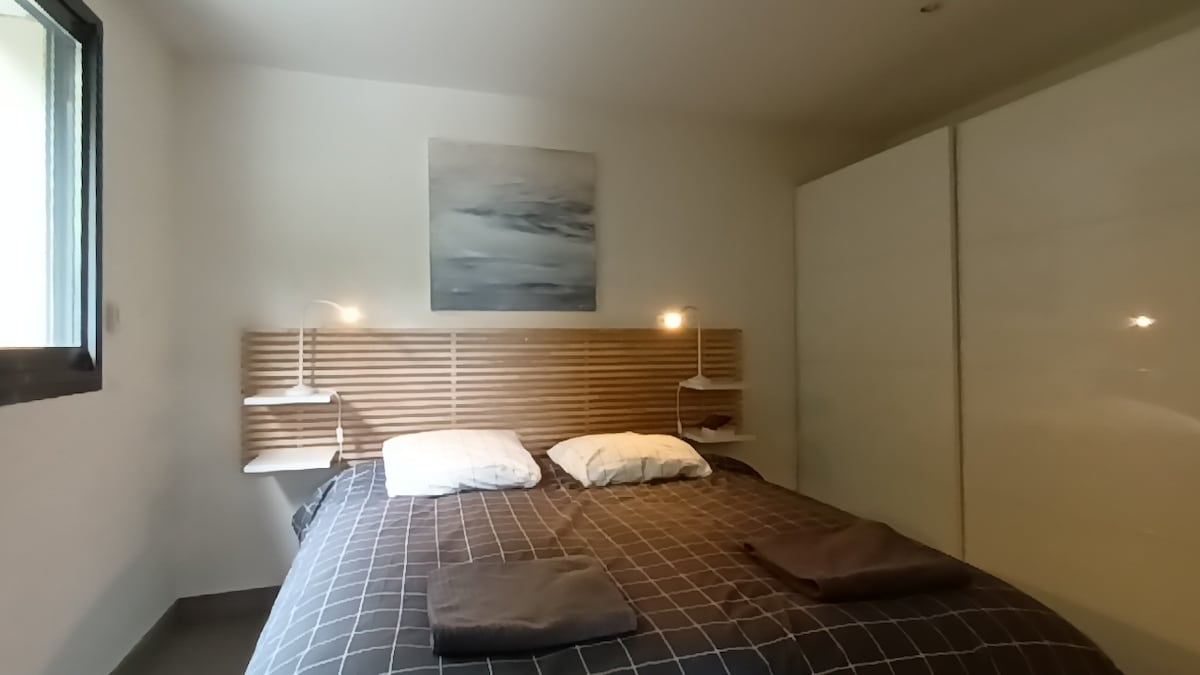 חדר שינה ראשי, מיטת קווין סייז וחדר רחצה, עם סטודיו ומטבחון המשקיפים על נוף לבריכה ולהרים 