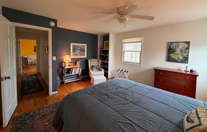 חדר שינה קווין למעלה עם פינת קריאה שקטה.