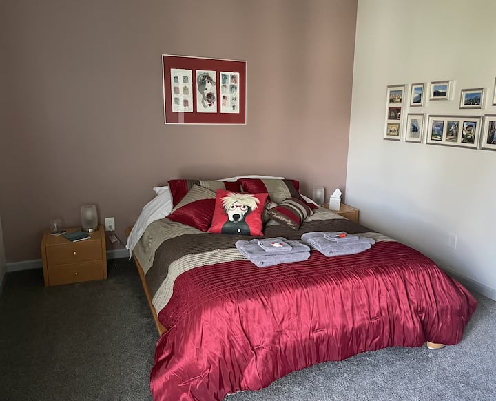 Camera da letto in stile europeo con asciugamani sul letto e comodini con lampade. Opere d'arte e quadri sulla parete.