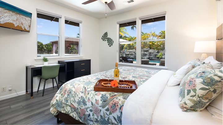 Primary bedroom with king bed and quality linens as well as a TV and a work space 