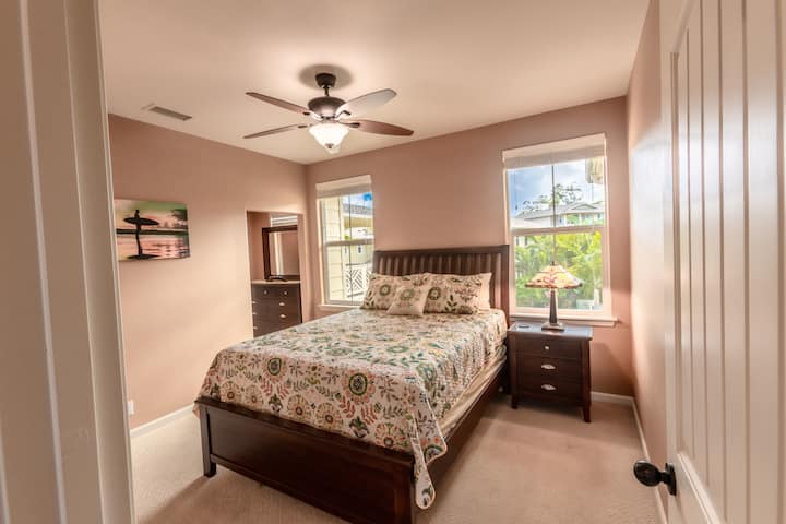 Relax in our comfortable second bedroom, featuring a plush queen-size bed, tranquil decor, and the added convenience of an attached private bathroom.