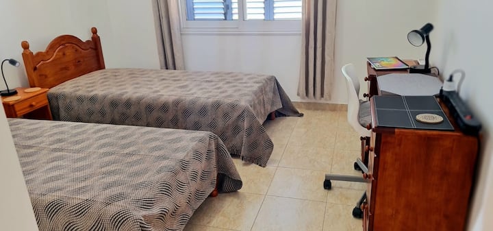 Spavaća soba s dva odvojena kreveta i radnim stolom