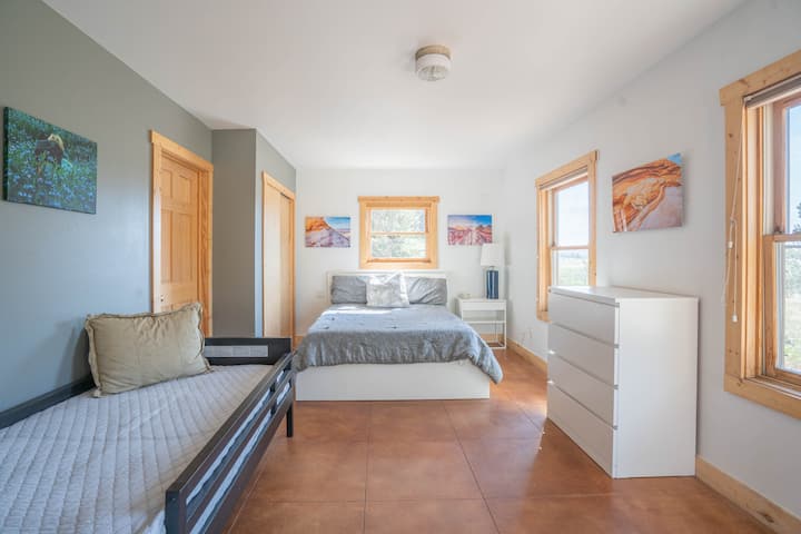 ห้องนอนใหญ่ชั้นล่างมีเตียงควีนไซส์ เตียงแฝด และประตูไปยังลานบ้าน