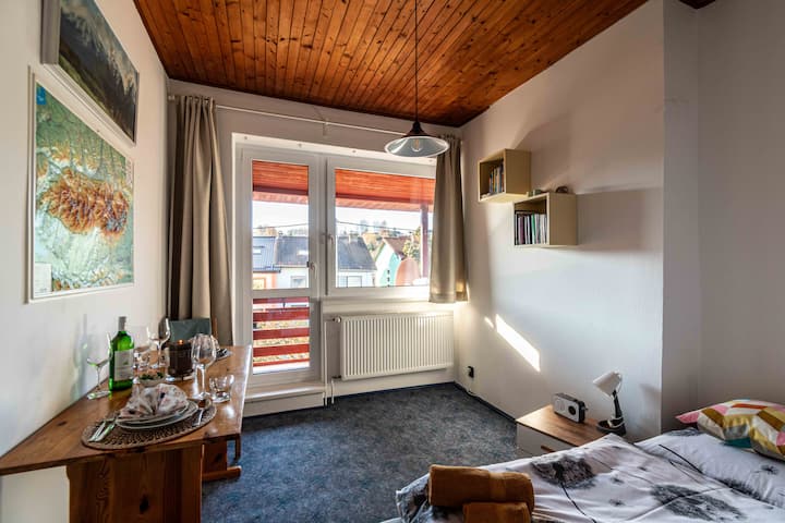 Dormitorio con cama matrimonial equipada con mesita de noche, armario, lámpara de noche, radio pequeña, mesa con sillas.  Habitación muy acogedora con balcón para parejas.