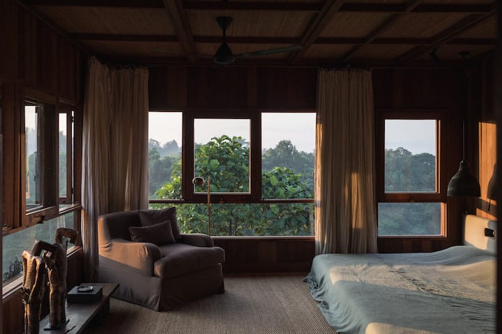 The primary bedroom has timber-clad walls, a generous surface of 32m2. The room’s ​Bangkirai ​timber floors are partially covered with soft natural carpeting from Sumatra. Low panoramic windows allow unobstructed views of Campuhan Ridge.
