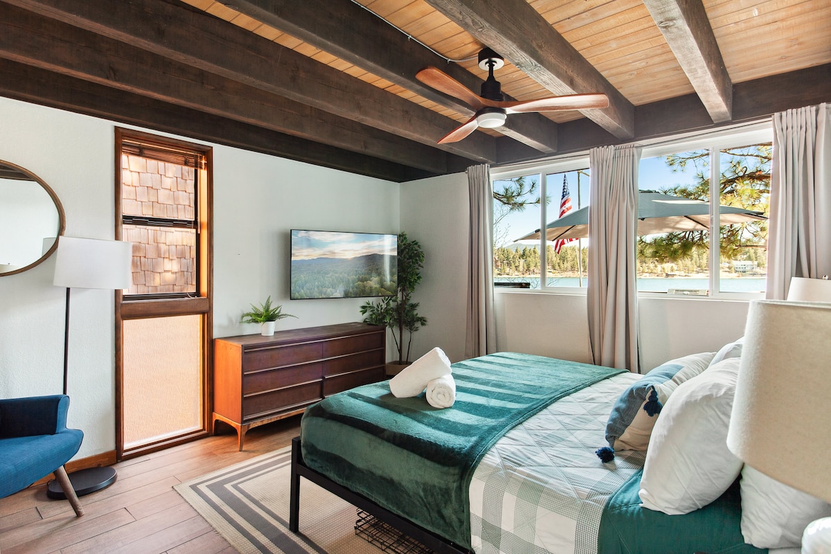 The primary bedroom, situated on the main level, boasts lake views, a walk-in closet, and a luxurious spa bathroom.