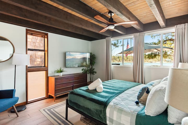 The primary bedroom, situated on the main level, boasts lake views, a walk-in closet, and a luxurious spa bathroom.