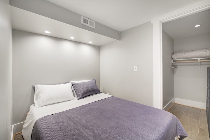 חדר שינה קטן למטה עם מיטה וארון עם שמיכה נוספת