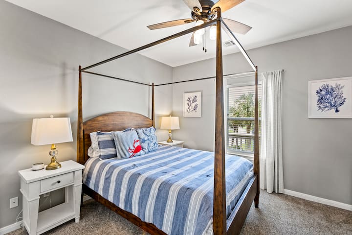 Relax in a stylish four-poster bed with serene views and charming coastal decor!