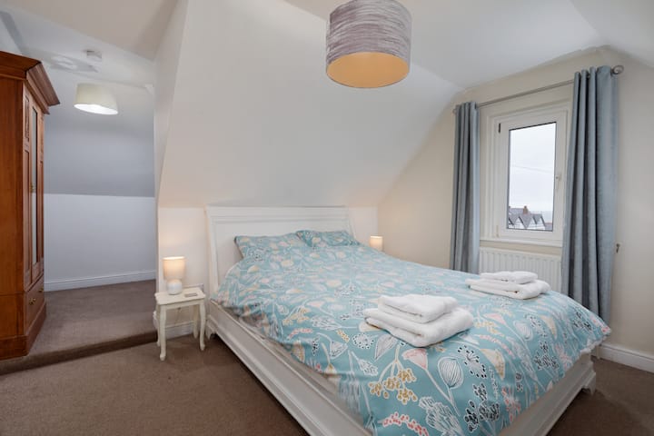 غرفة نوم داخلية مزدوجة في الطابق الأول مع سرير بمقاس كبير وخزانة ملابس.