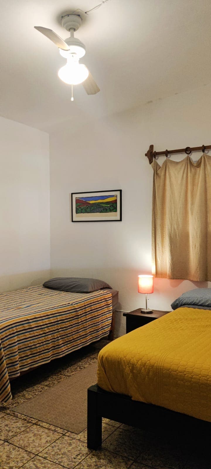 Manželská a samostatná posteľ, podlahová rohož. Ambientný stôl a lampa, stropný ventilátor s osvetlením. Okná s ochranou a sieťkou proti komárom.