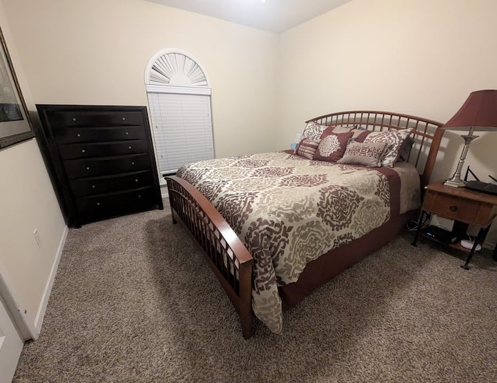 Cama queen en la habitación 1 con cómoda y mesitas de noche