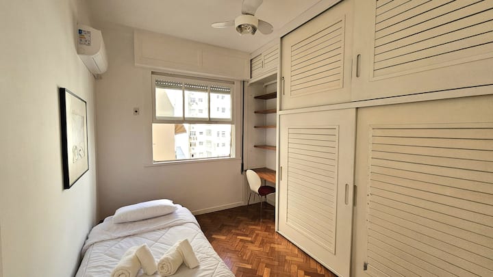 חדר שינה 3 עם מיטת יחיד, מיזוג אוויר, מאוורר תקרה, שולחן עבודה וארונית מלאה.