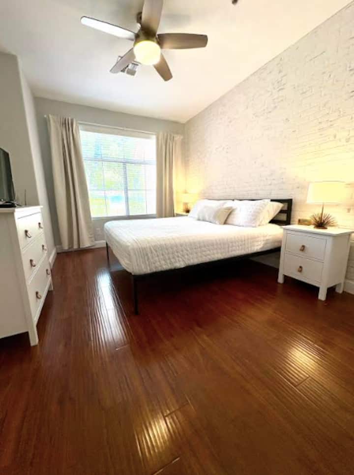 Chambre principale avec lit king size, télévision intelligente, commode, deux tables de nuit, placard et penderie