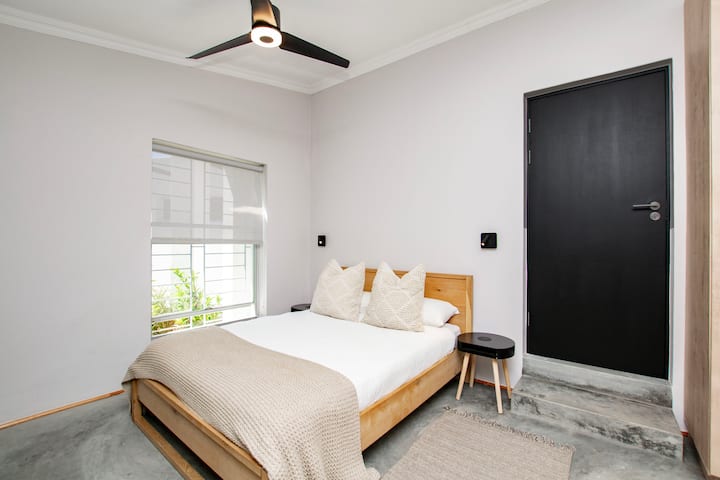 Chumba cha 1 cha kulala ni fleti ya studio ya kujitegemea iliyo na kitanda cha watu wawili, kochi la kulala, chumba cha kupikia, na bafu la chumbani. Milango iliyofunguliwa kwenye baraza ya kujitegemea, ikitoa mapumziko tulivu na yenye starehe yenye mlango wake mwenyewe na ufikiaji wa ndani.