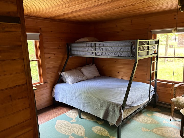 غرفة نوم تضم سريرين مفردين فوق سرير بحجم كوين