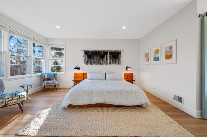 استمتع بخصوصيتك في غرفة النوم الرئيسية ذات الحجم الكبير هذه.