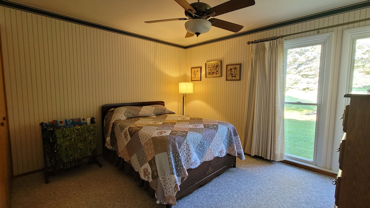 تحتوي غرفة النوم هذه على مرتبة مزدوجة على سطح الوسادة ومروحة سقف وإطلالات على المساحة الخلفية حيث يمكنك في كثير من الأحيان رؤية الغزلان والتركي ورافعات ساندهيل.  يوفر فتح النوافذ نسيمًا متقاطعًا من هواء الريف رائعًا لقضاء ليلة جيدة.
