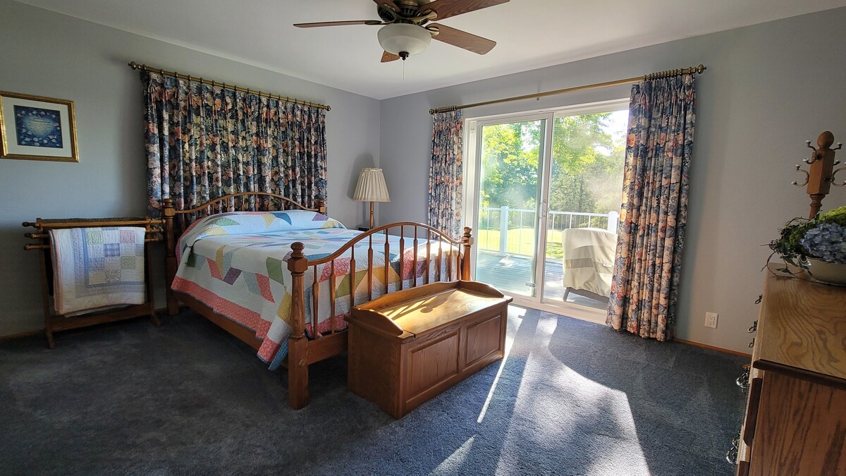 تحتوي غرفة النوم الرئيسية على جدار باب على سطحنا الذي تبلغ مساحته 1200 قدم مربع، ويطل على شروق الشمس في الصباح فوق البحيرة.