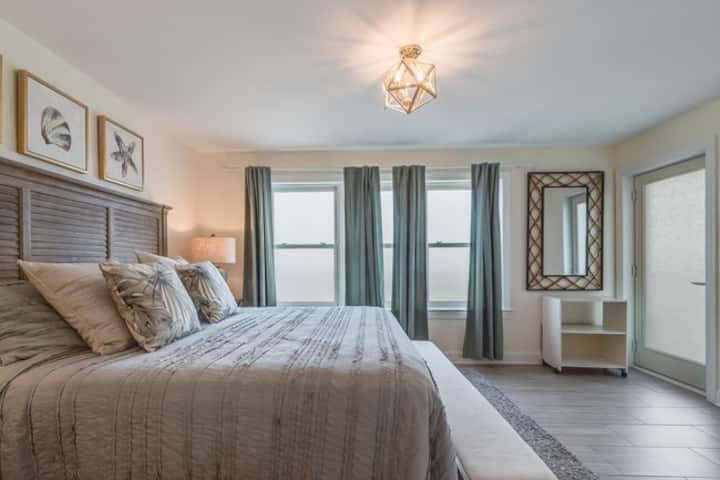 King size master bedroom with private master bathroom and view of bayside beach pamoja na mlango wa kujitegemea wa roshani ambao unaangalia ghuba 