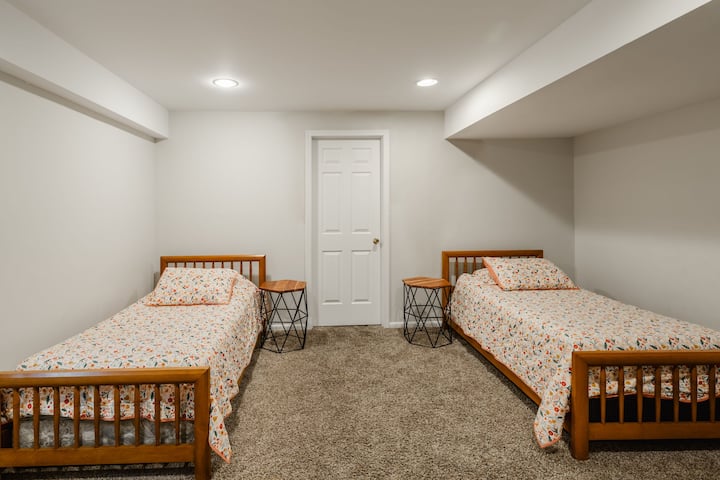 Dhomë gjumi në bodrum me dy krevate tek.