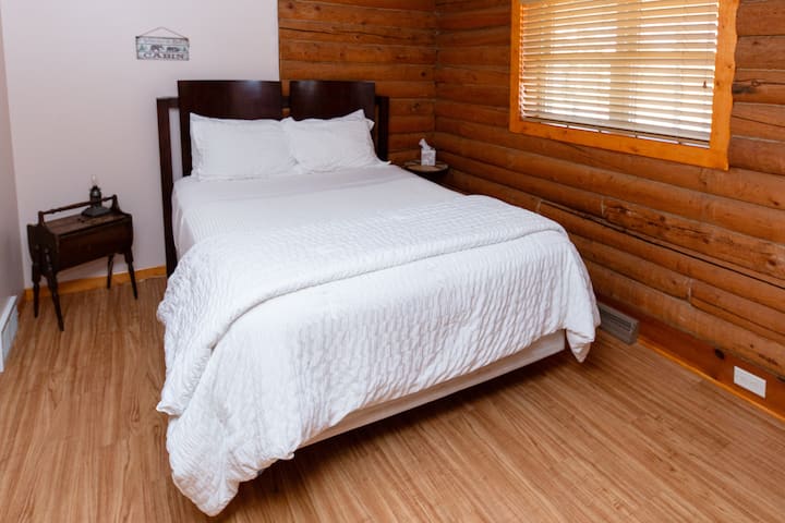 Relax in the first bedroom, featuring a comfortable queen-sized bed, ample closet space, and two dressers for all your belongings.