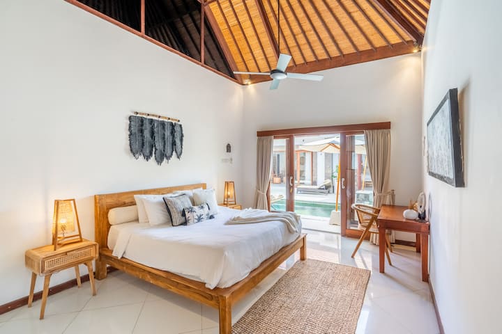El dormitorio n.º 3 de Villa Jiwa ofrece una lujosa cama tamaño king, un elegante baño privado con bañera y vistas serenas a la piscina cristalina.