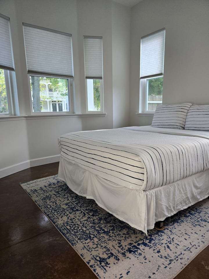 La nostra accogliente seconda camera da letto, amata per i suoi letti comodi e il fascino nostalgico. Goditi la vista panoramica incorniciata dall'iconica parete ad arco, con ombre per la privacy. Soggiorna da noi, prenota subito.