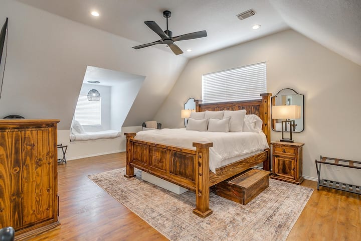 Ghorofa kuu ya chumba cha kulala cha kifalme kilicho na trundle pacha chini yake.  Viti vya ngazi vinavyotolewa pande zote mbili kutokana na ufikiaji rahisi wa kuingia/kutoka kitandani .