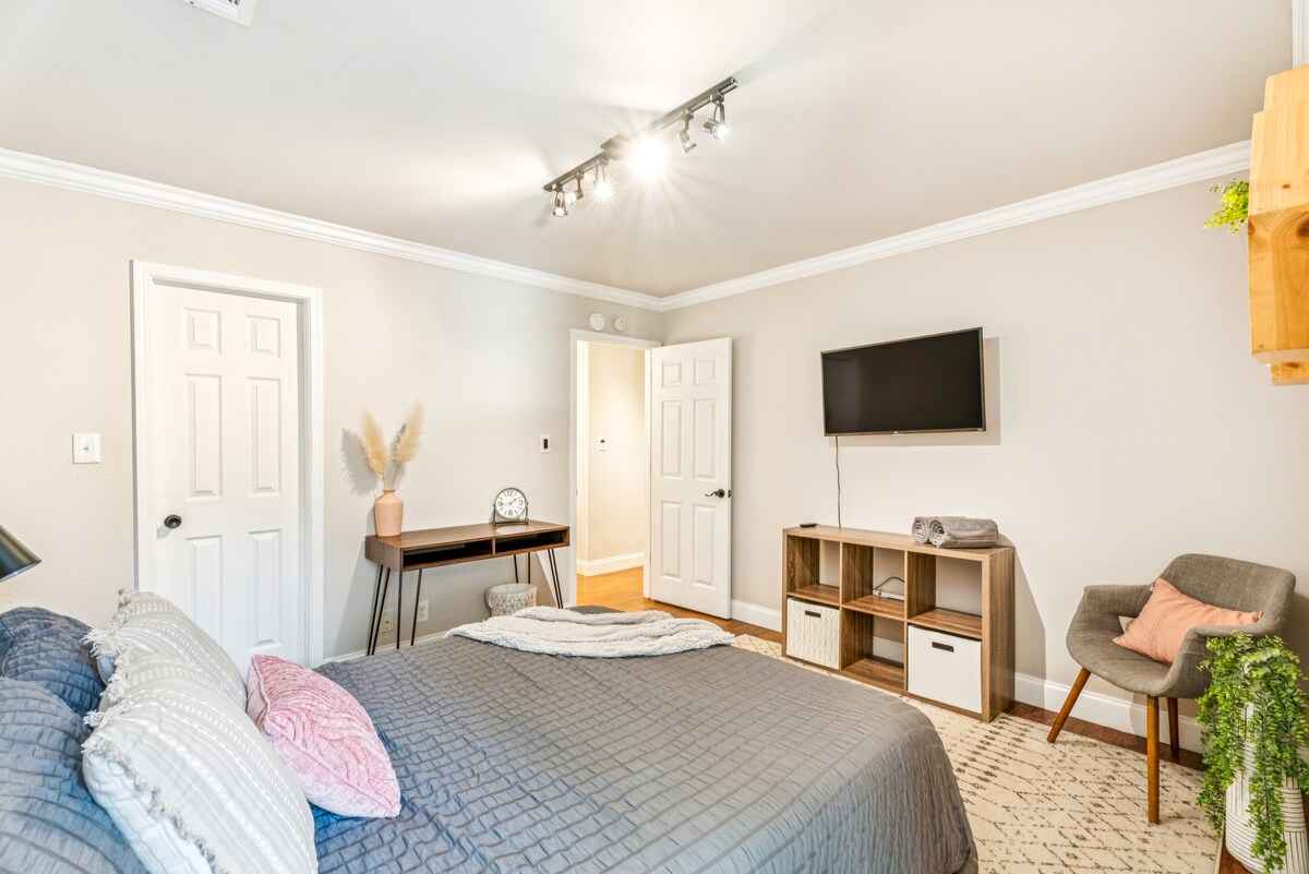 ห้องนอน 2 - ห้องนอนที่อบอุ่นและสว่างไสว มีเตียงนอนสบายพร้อมผ้าปูที่นอนนุ่ม ทีวีติดผนัง โต๊ะทำงานสไตล์มินิมอล และเก้าอี้ที่มีสไตล์ โทนสีที่เป็นกลางและการตกแต่งที่เรียบง่ายช่วยสร้างบรรยากาศที่สงบและน่าอยู่