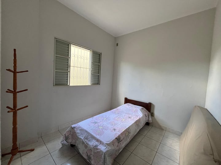 Chambre avec 1 lit simple et 1 autre matelas, vue sur le couloir