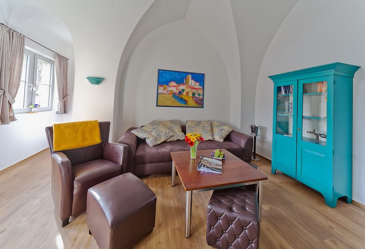 Sebule yenye starehe kwenye ghorofa ya 1 inakualika ukiwa na kona ya kusoma na sofa kubwa yenye starehe, ambayo inaweza kutumika kama malazi kamili (sentimita 160x200). 