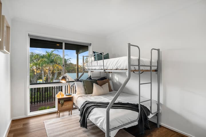 明亮迷人的双层床房，配备单人床和双人床，非常适合家庭入住。