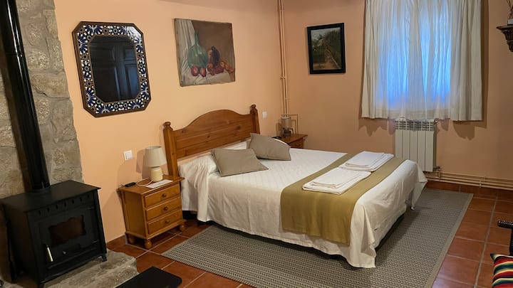 Bedroom "Las Encinas". On the ground floor, it has a 135 cm double bed and fireplace.