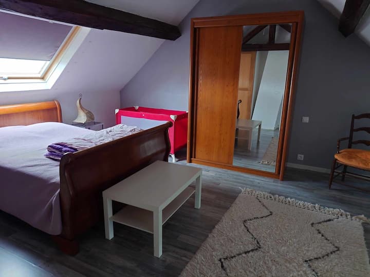 Priestranná spálňa s veľkým šatníkom, veľkým kreslom a detskou postieľkou