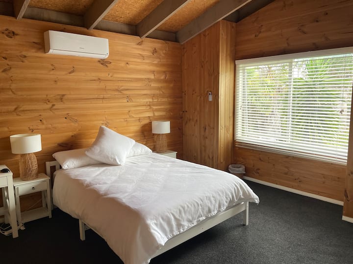 Dormitorio queen superior oeste con vista al jardín, calefacción/refrigeración de ciclo inverso y armarios empotrados. También tiene un escritorio de trabajo con monitor, teclado y ratón por si necesitas hacer un poco de trabajo.