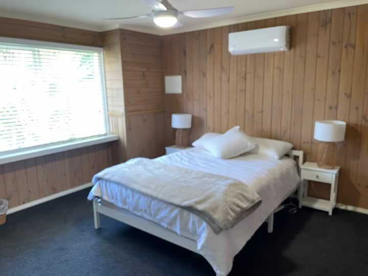 Dormitorio queen inferior este con vista al jardín, calefacción/refrigeración de ciclo inverso y armarios empotrados.