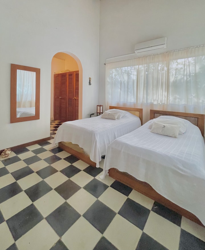 卧室1
最多可供2人入住，配备两张单人床。 更衣室配有专属卫生间和淋浴间、空调、吊扇和可俯瞰棕榈树的窗户。 