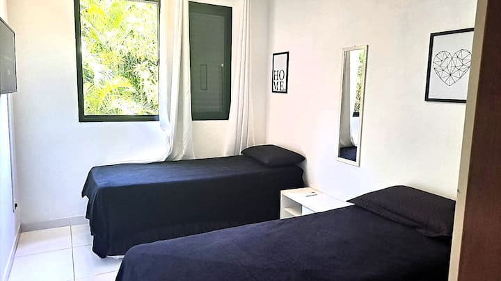 Segundo quarto com 2 bicamas, acomodando até 4 pessoas em camas de solteiro, e uma incrível vista para a mata. Conta com espelho, ar-condicionado quente e frio, rack retrátil que funciona como escritório, amplo armário e Smart TV Samsung de 32''.