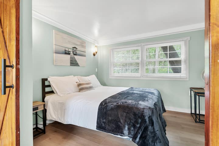 Este es el dormitorio zen. Pintado en verde zen, con puertas corredizas de madera que te encierran, estás rodeado de tonos naturales que te atraen. Las mesitas de noche a cada lado están equipadas con 2 puertos USB y 2 enchufes.