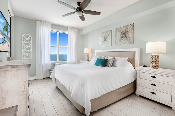 Primaire slaapkamer met kingsize bed en uitzicht op de oceaan.