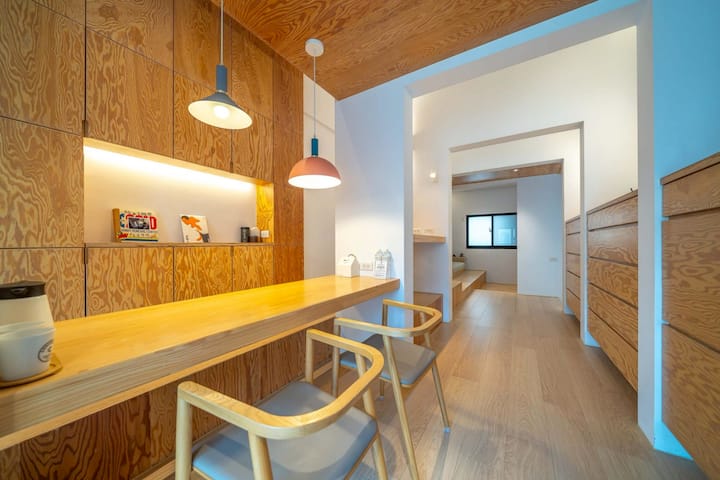 Ექსკლუზიური მთლიანი იატაკი | ხით დაფარული დიდი ტევადობის სათავსო და გრძელი მაგიდები ქმნის წყნარ კუთხეს, როგორიცაა პირადი სტუდიო.