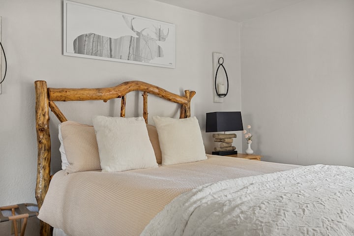 El dormitorio 2 en el refugio Big Bear Lake cuenta con una cama tamaño queen con una decoración elegante, elementos esenciales como toallas y sábanas, almohadas adicionales, una plancha, una caja fuerte, una ventana y un amplio espacio de almacenamiento con armario y cómoda.