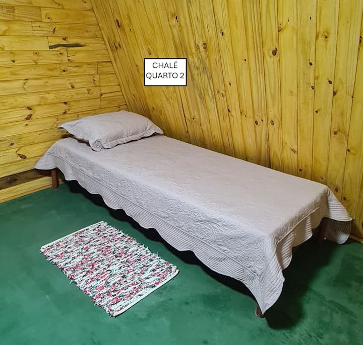 كوخ - غرفة نوم 2، في الطابق الأول. يحتوي على سرير مزدوج وسرير مفرد. تحتوي الغرفة على نافذة وإمكانية الوصول إلى المنطقة الخارجية. تحتوي الغرفة أيضًا على حمام مع دش، يتم مشاركته مع الشاليه بأكمله.