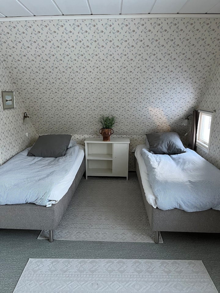 Bedroom 3 upstairs with two single beds, table with chairs, mirror and closet. 