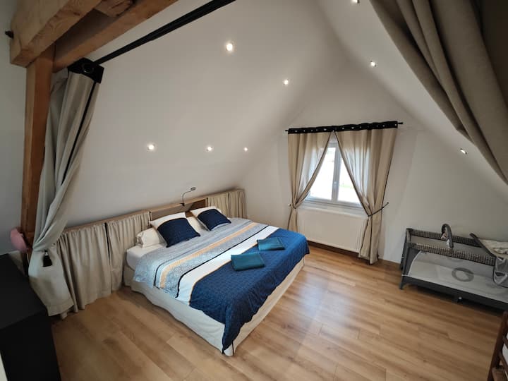 Esta es la segunda habitación. Situada en un espacio abierto en el piso de arriba, está separada por una gran cortina para mayor privacidad. Disfrute de la cama king size, una cuna de madera y una mesa para cambiar pañales (no visible en esta foto).