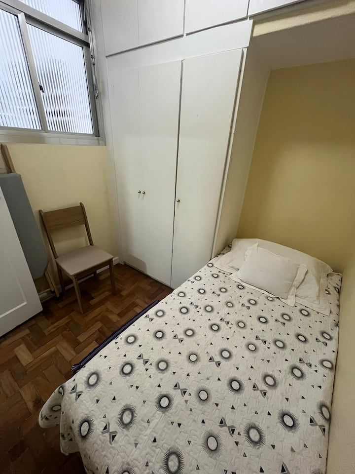 房间配有单人床、橱柜、风扇和床上用品。 