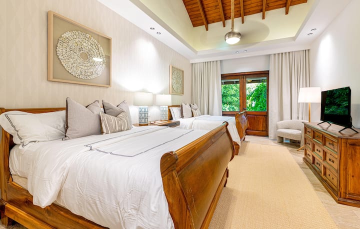 Fourth bedroom with 2 queen beds, en suite full bathroom, split unit AC, and patio with outside seating