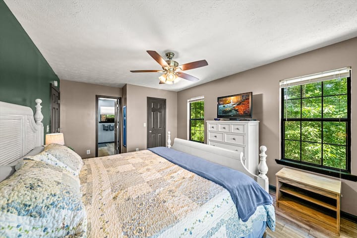 Glavna spavaća soba s TV-om, stropnim ventilatorom i privatnom kupaonicom.