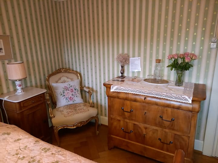 Gobelin-bestickter Sessel und antikeKommode im Gästezimmer "Rose"